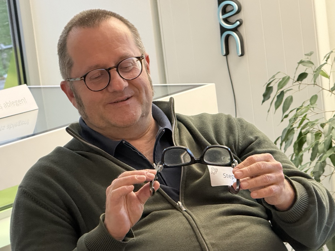 Stephan Berkowitz hält die Brille von Ray Ban und Meta in den Händen un betrachtet sie eingehend.